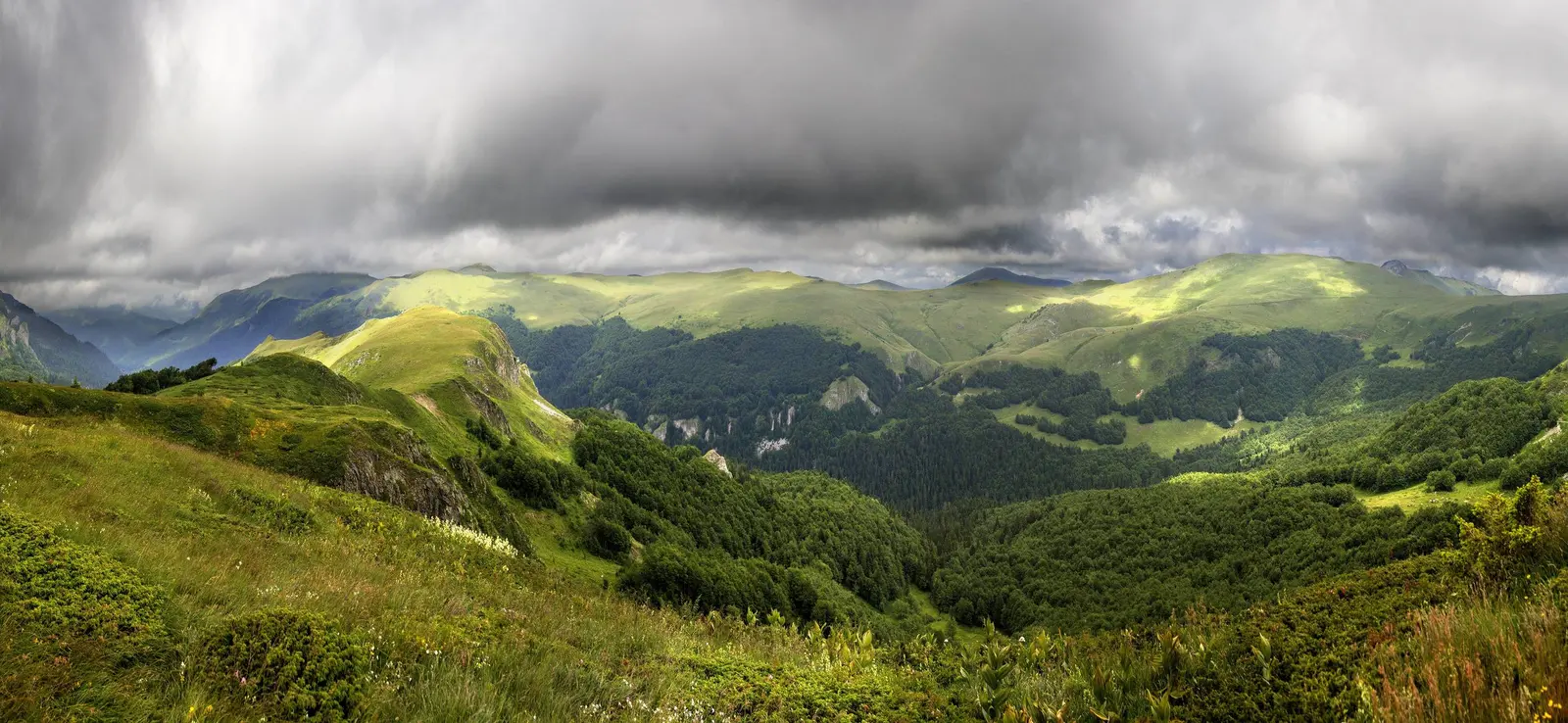 Dark rain clouds crossing green ridges and forested valleys on Bjelasica